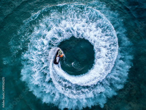 People are playing a jet ski in the sea.Aerial view. Top view.amazing nature background.The color of the water and beautifully bright. Fresh freedom. Adventure day.clear turquoise at tropical beach.