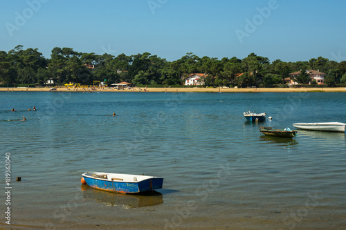 French Hossegor lake with swimmers and boats during a summer day.