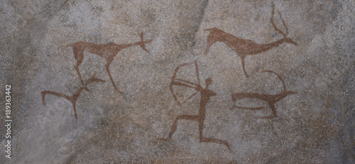 Drawing in a cave painted by a caveman - a wall of rock.