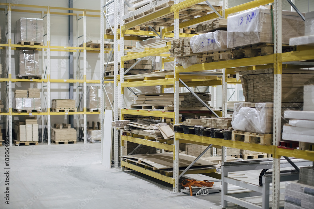 Stack of wooden planks on racks in distribution house Stack of wooden planks on racks in distribution house