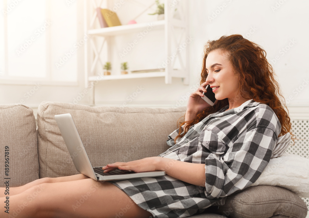 Girl with laptop and mobile sitting on beige couch. Girl with laptop and mobile sitting on beige couch.