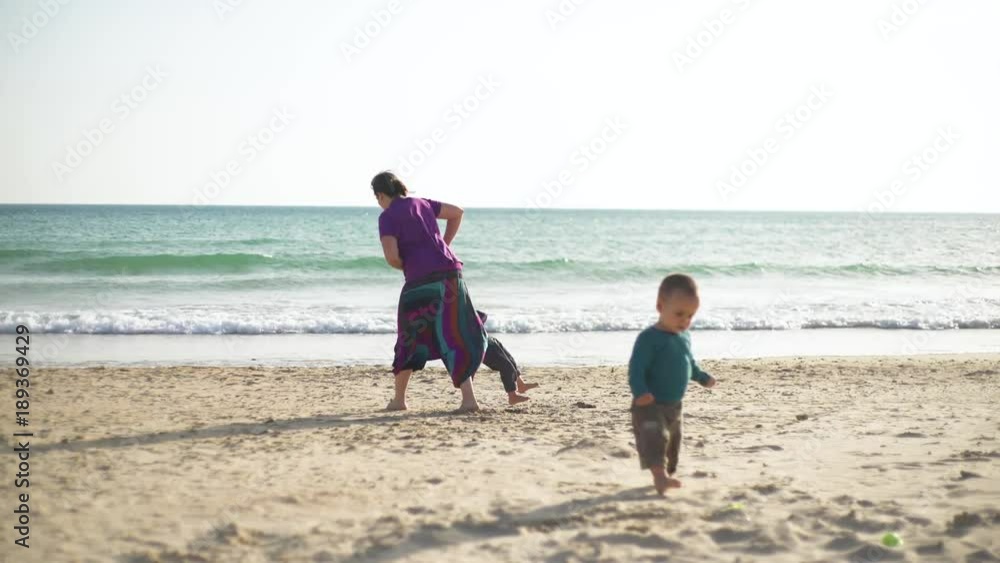 Young family in the beach playing and enjoying together, smiling, in a loving way Young family in the beach playing and enjoying together, smiling, in a loving way