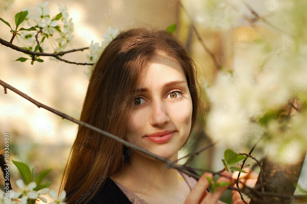 A pretty girl resting in the shade of blooming cherries A pretty girl resting in the shade of blooming cherries