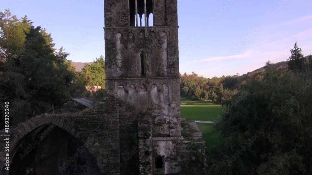 aerial view of an ancient abandoned church with tower and golf green field on back aerial view of an ancient abandoned church with tower and golf green field on back