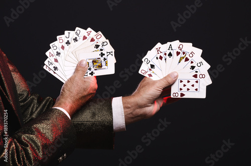 Magician shows trick with playing cards. Manipulation with props. Sleight of hand.