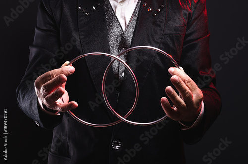 Magician shows trick with metal rings. Manipulation with props. Sleight of hand.