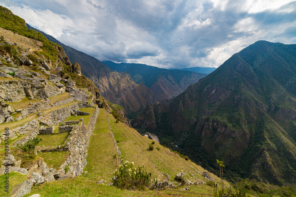 Machu Picchu terraces steep view from above to Urubamba valley below. Peru travel destination, tourism famous place.