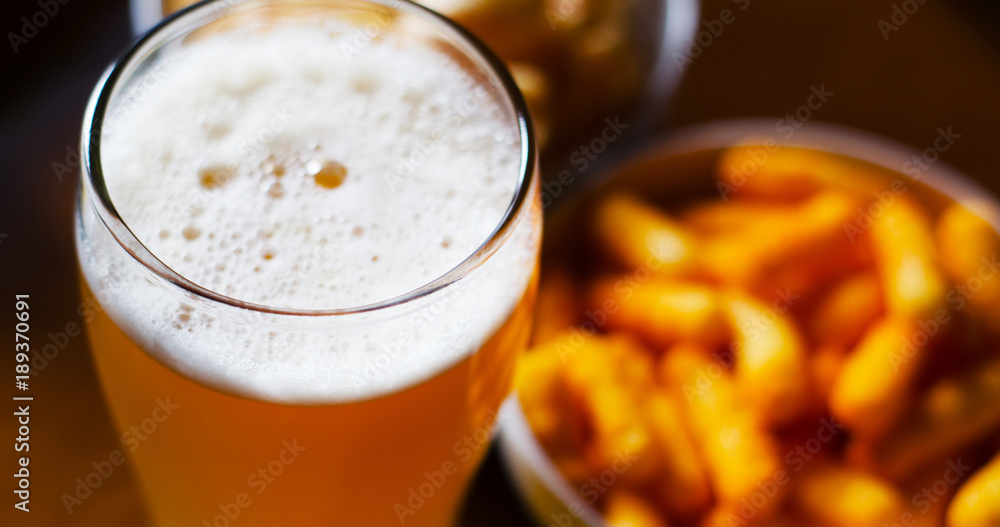 pint of lager beer in a glass, set of various snacks, a standard set of drinking and eating in a pub pint of lager beer in a glass, set of various snacks, a standard set of drinking and eating in a pub