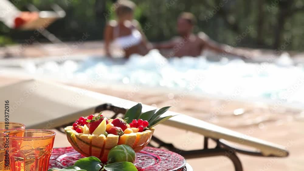 coffee table with fruit salad and man and woman in a jacuzzi coffee table with fruit salad and man and woman in a jacuzzi