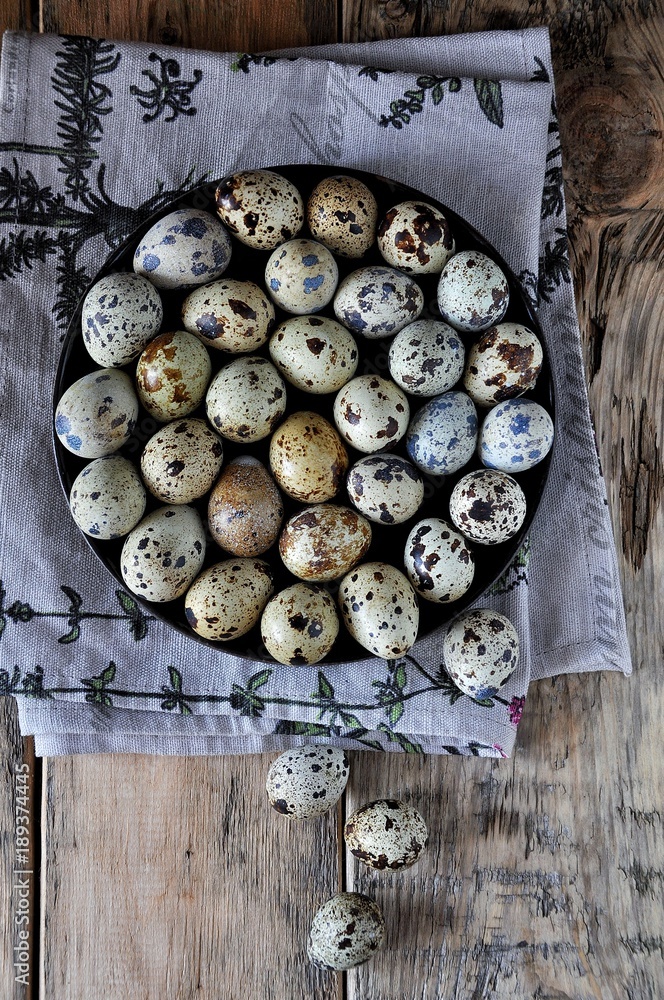 On cotton napkins quail eggs on a platter, wooden background On cotton napkins quail eggs on a platter, wooden background