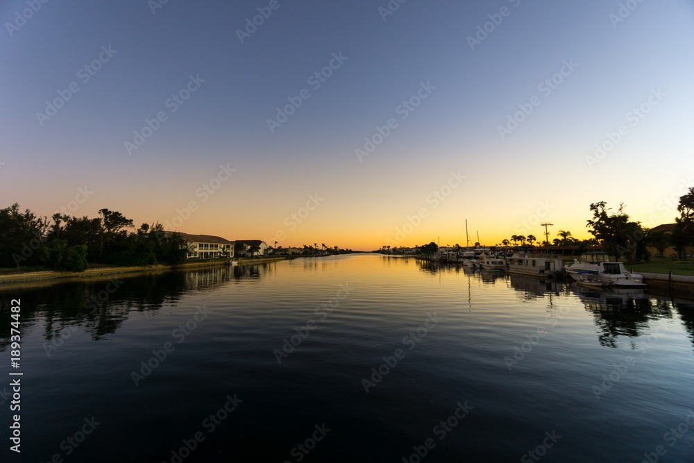 USA, Florida, Sunset behind water of large river with boats and houses