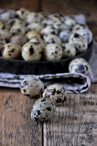 On cotton napkins quail eggs on a platter, wooden background