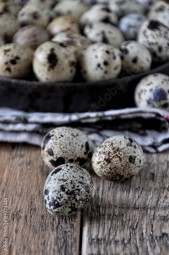 On cotton napkins quail eggs on a platter, wooden background