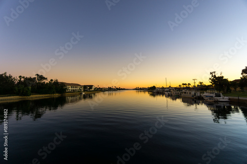 USA, Florida, Sunset behind water of large river with boats and houses