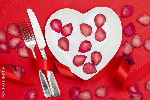 Valentine's day meal concept. Heart shaped plate with knife and fork © ink drop