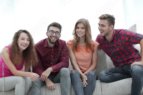 group of cheerful young people sitting on the couch.