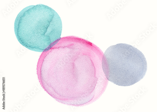 Composition of three circles painted in pink, grey and teal green watercolor on clean white background