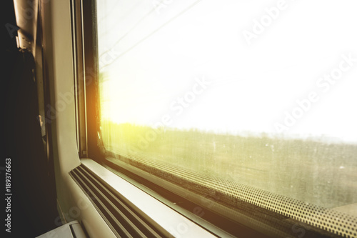 Traveling by train: look out the window at a moving landscape at sunset