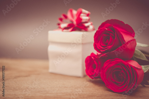 Valentines Day Background with Gift Box and Red Rose on Wood Table Rustic style