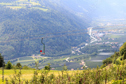 Chairlift, apple trees and mountain panorama in Algundo, South Tyrol