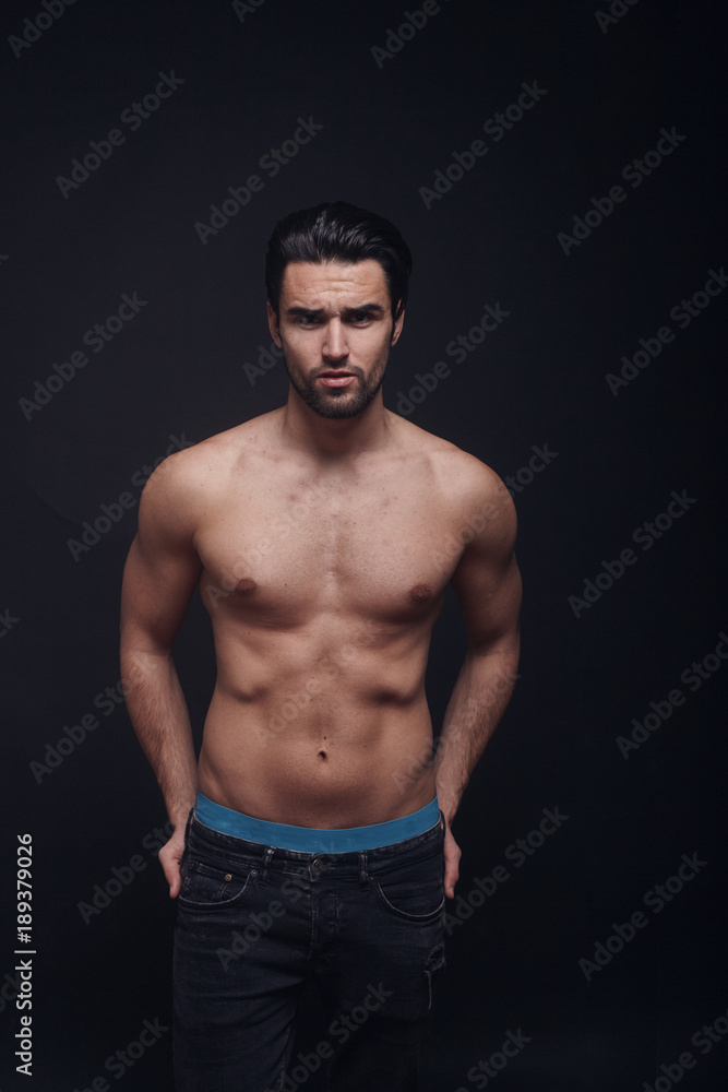 handsome man, fasion model, posing in jeans, black background, shirtless, looking at camera. handsome man, fasion model, posing in jeans, black background, shirtless, looking at camera.