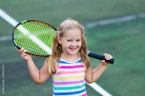 Child playing tennis on outdoor court