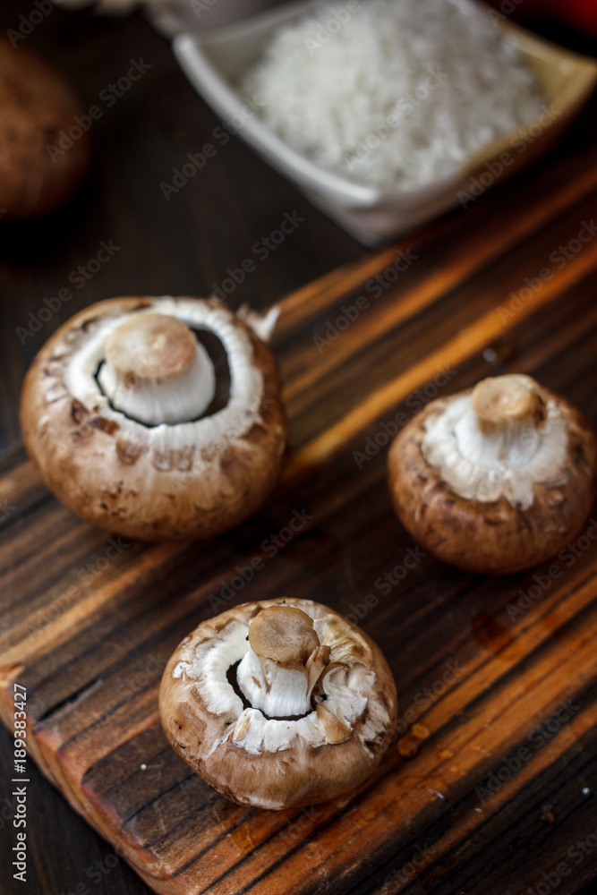 Mushrooms on board with fresh vegetables on background. Mushrooms on board with fresh vegetables on background.