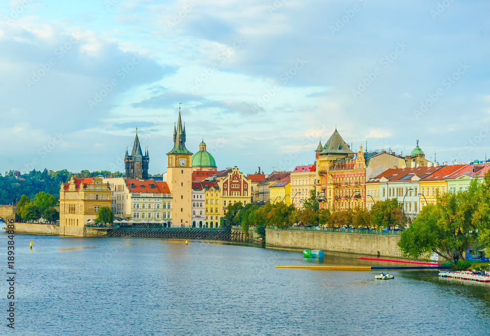 The Mill peninsula and the Charles Bridge in Prague in the Czech Republic at sunset. Boats on the Vltava River