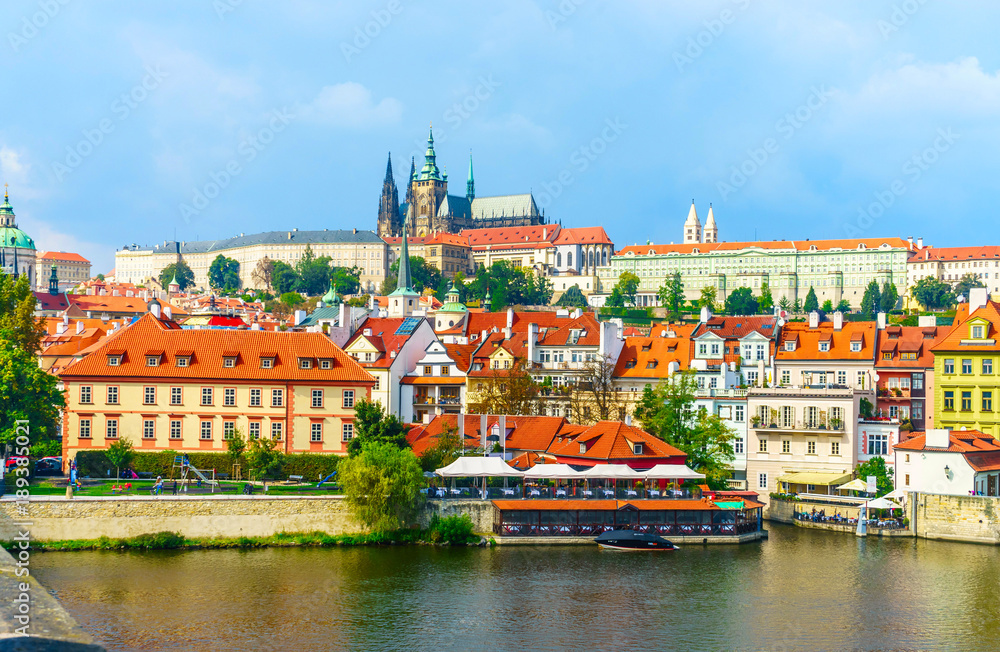 Fototapeta premium Prague Castle. The Charles Bridge. Medieval fortress. The Vltava River. Red tiled roofs. View from Charles Bridge