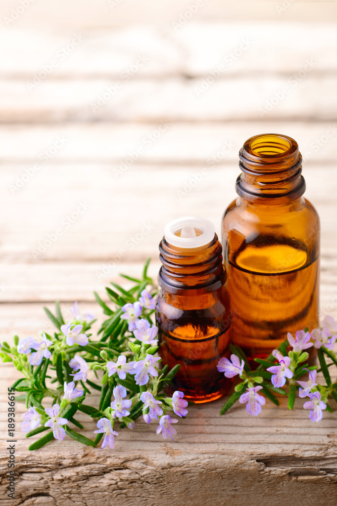 fresh rosemary flowers and essential oils on the table fresh rosemary flowers and essential oils on the table