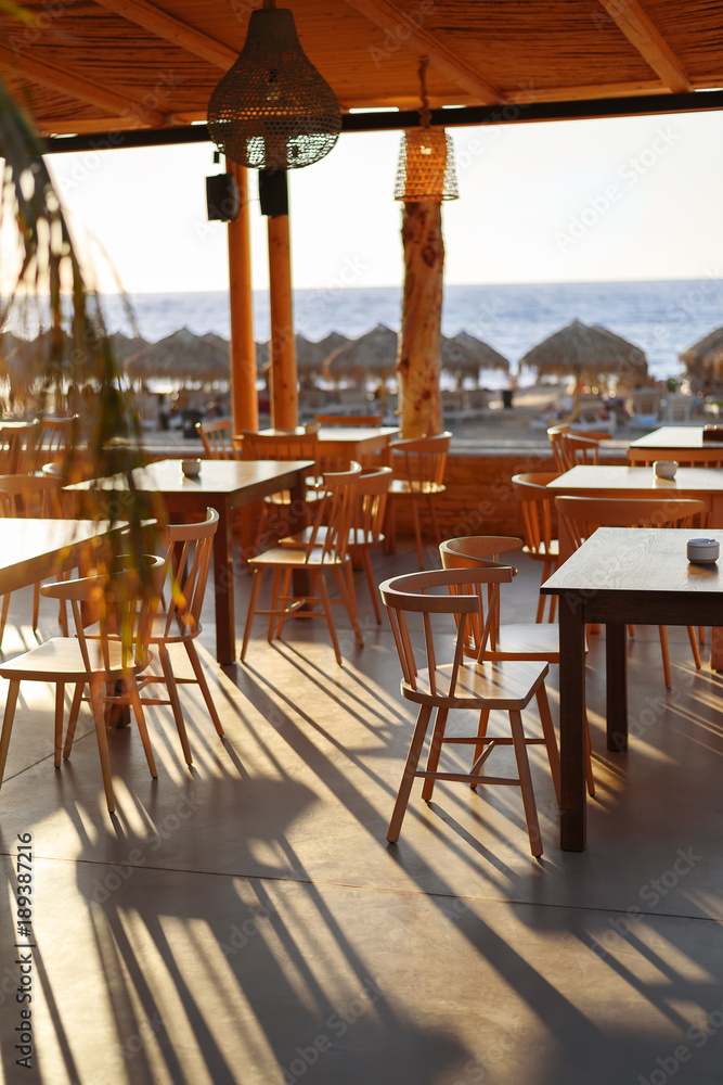 The restaurant on the beach in the shade of the low sun at sunset