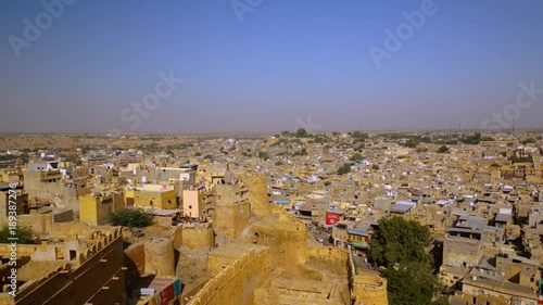 Still shot of the jaisalmer cityscape with the fort walls in the foreground. The city houses the famed living fort the golden fort or Sonar quila of the city. Jaisalmer is a famous tourist destination photo