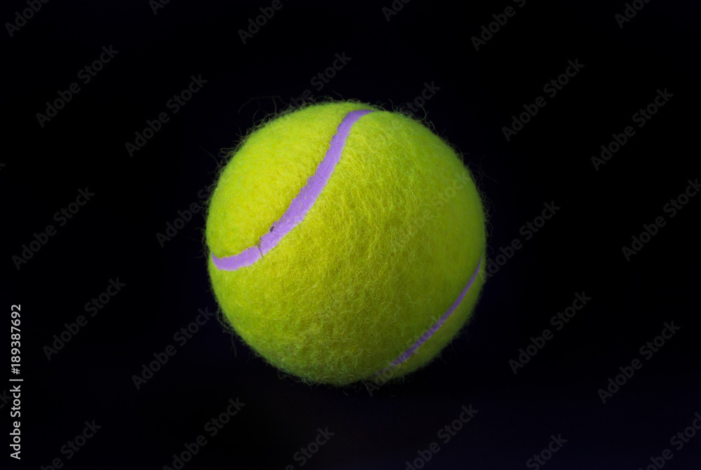 Felt tennis ball isolated on black background. Tennis ball photo for banner template.