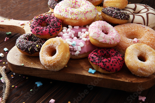 assorted donuts with chocolate frosted, pink glazed and sprinkles donuts.