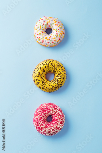 Donuts selection on blue background. Various doughnuts isolated on colorful background