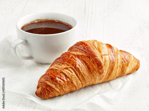 freshly baked croissant and coffee cup