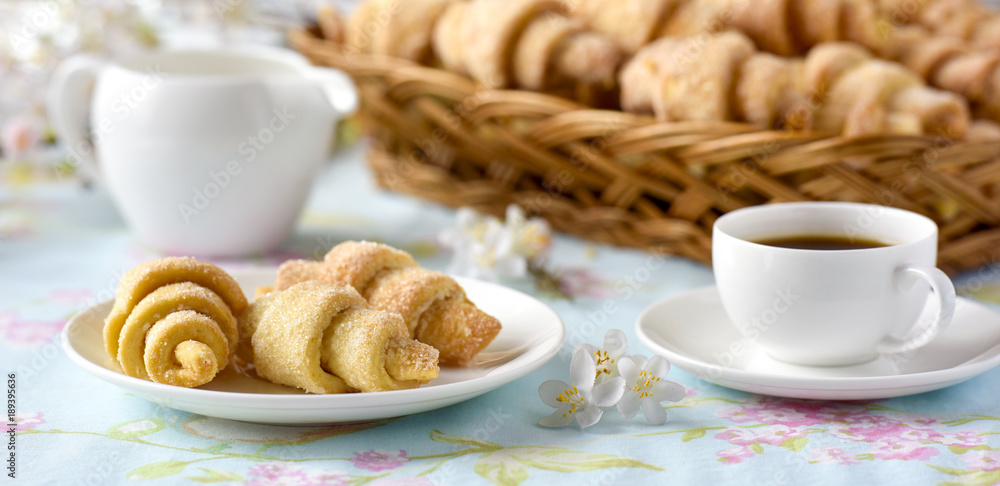 Many croissants on a table with spring flowers Many croissants on a table with spring flowers