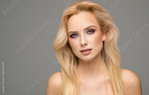 Portrait of blond female model with natural skin and blue eyes