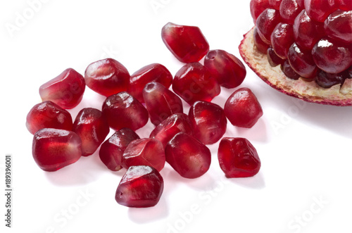 Pomegranate seeds and piece isolated on white background.