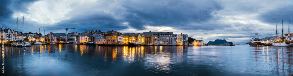 Sunset panorama of Alesund. Scenic view old city with reflection on water