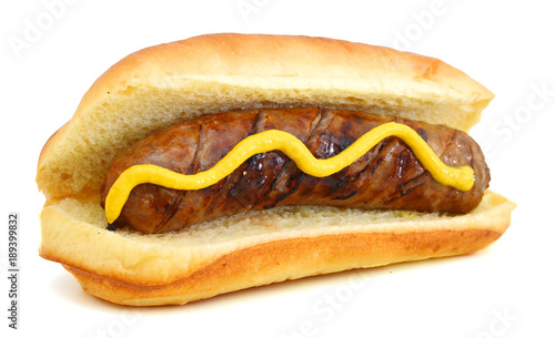 Grilled Bratwurst with mustard on bun. Isolated. photo