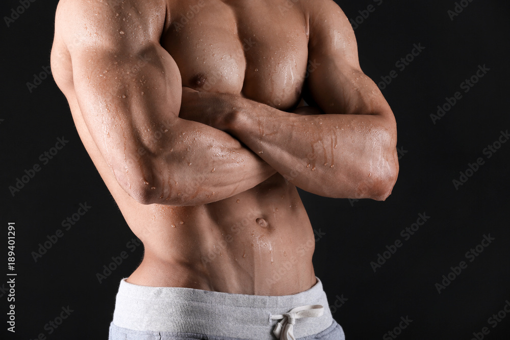 Handsome muscular young man with drops of sweat on skin against black background, closeup Handsome muscular young man with drops of sweat on skin against black background, closeup