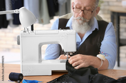 Senior tailor working on se...