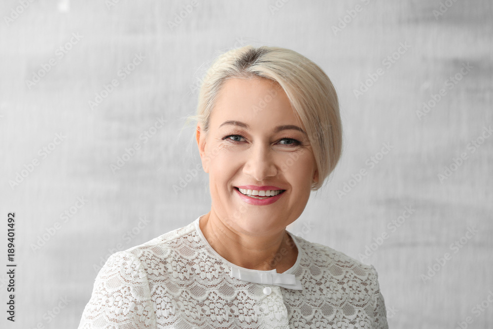 Obraz premium Portrait of beautiful mature woman on grey background