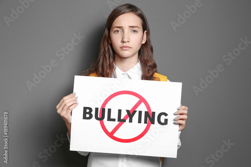 Teenage girl holding sign w...