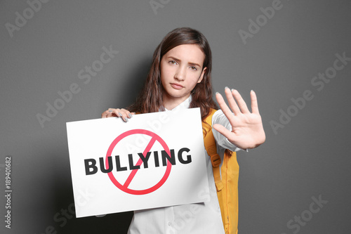 Teenage girl holding sign w...