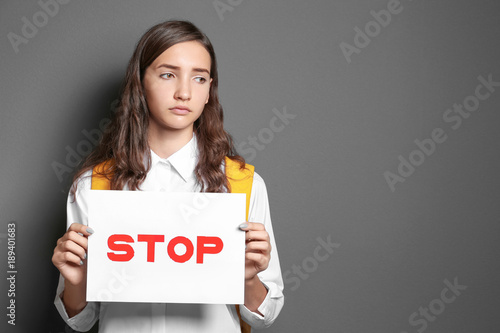 Teenage girl holding sign w...