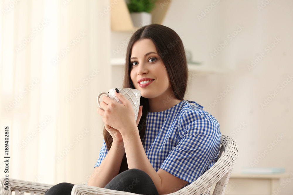 Beautiful smiling woman with cup of tea at home