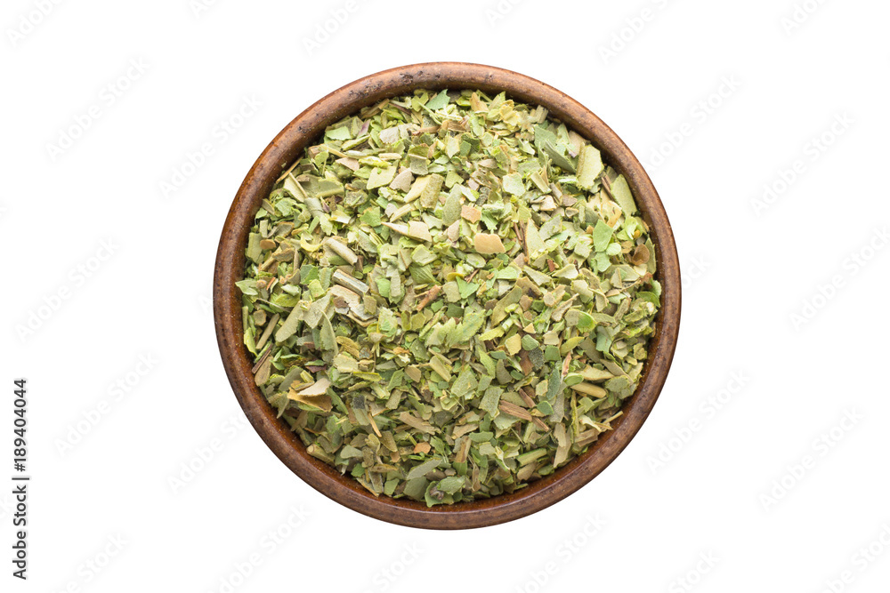 dried oregano spice in wooden bowl, isolated on white background. Seasoning top view