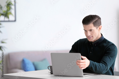 Young man using laptop at t...
